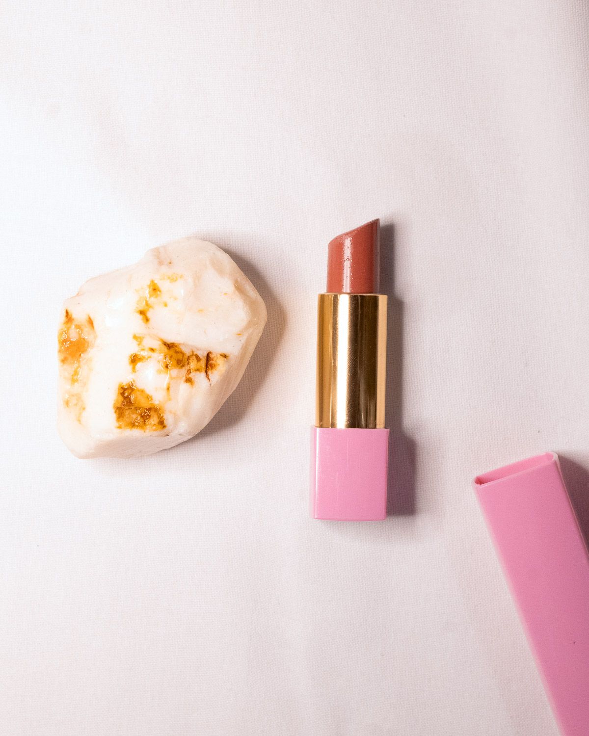 Opal No. 004 beside a pink and gold lipstick