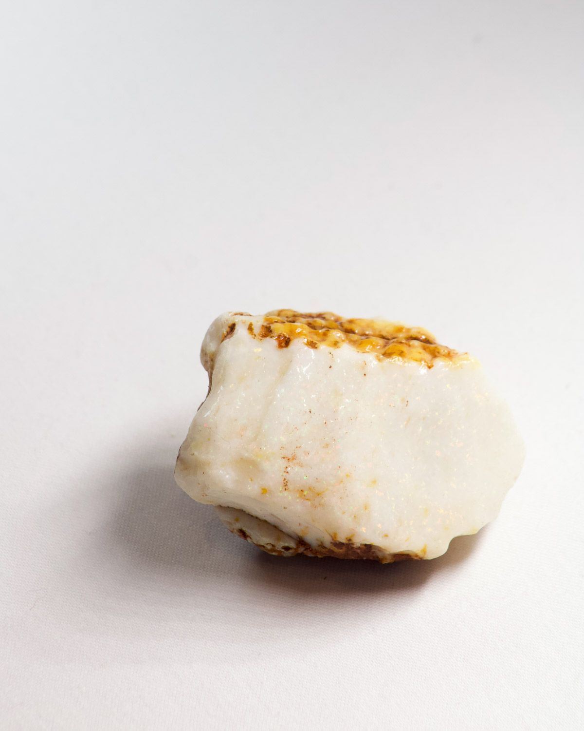 Opal No. 013, white face showing pin fire under an ochre ironstone crown
