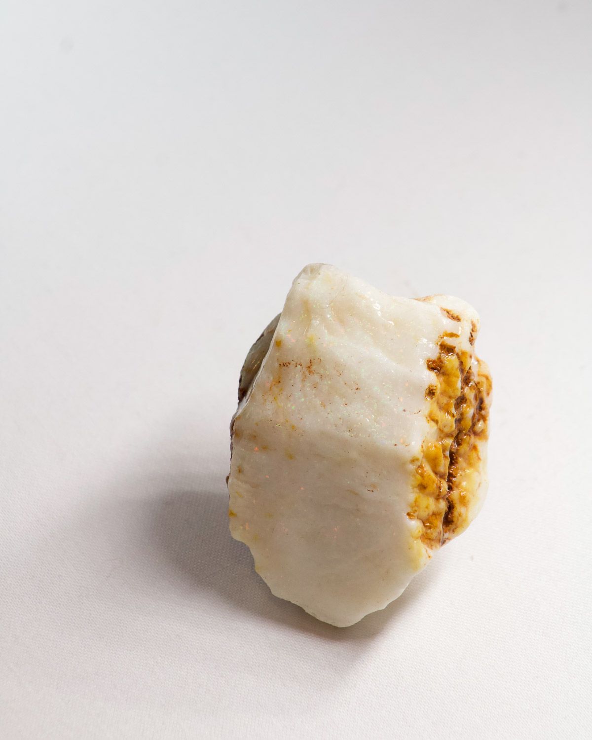 Opal No. 013, side showing pin fire with an ochre ironstone edge