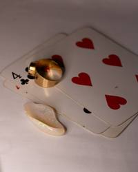 Opal No. 016 beside a gold ring and playing cards