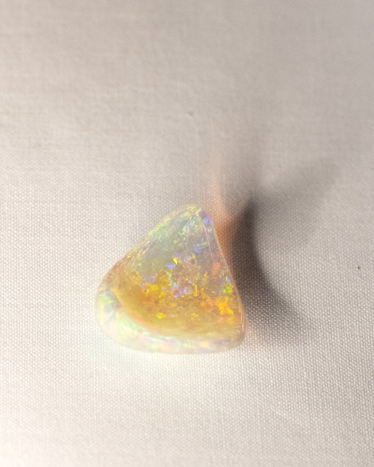 Opal No. 017, rounded triangle with gold, green and violet fire