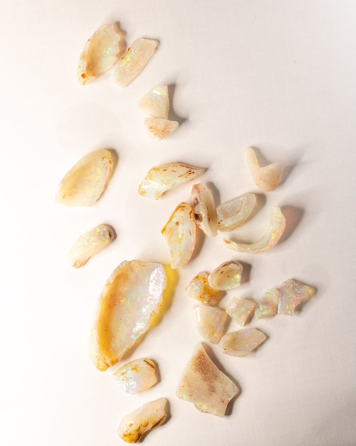Opal No. 019, a lot of raw white opal pieces scattered on linen